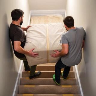 Technicians carrying a heavy item up a stairway with pads